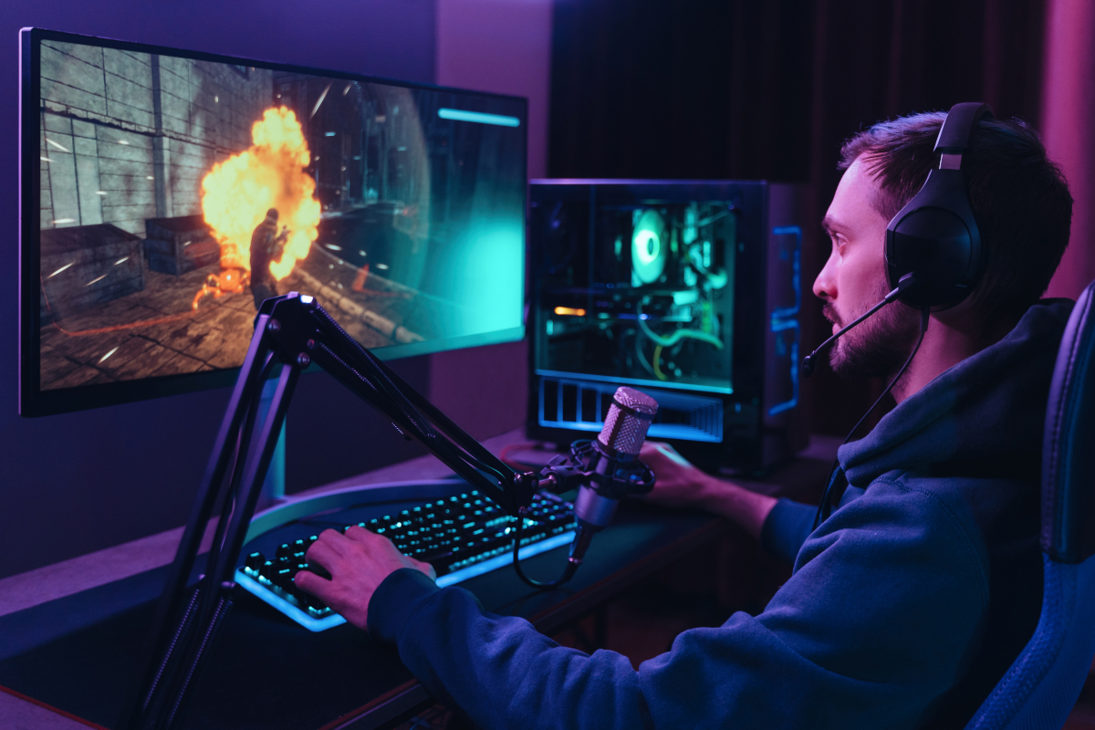 homme concentré devant un pc gaming jouant aux jeux vidéos